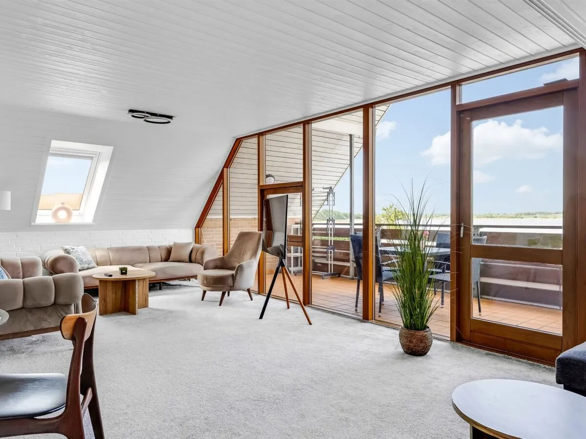Stuen set mod balkonen med lænestol og grønne planter