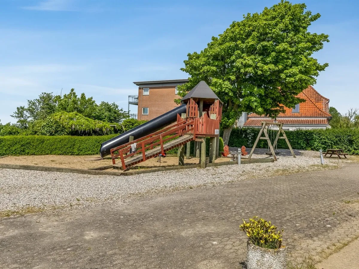 Legepladsen med rutsjebane og gynger lige ved huset